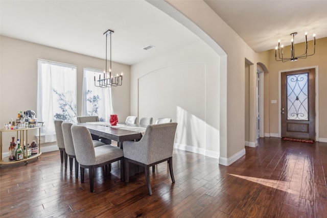 dining area featuring a notable chandelier and dark hardwood / wood-style flooring