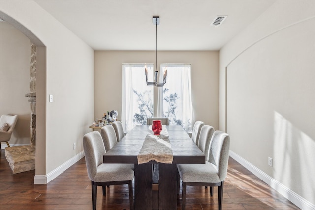 dining room featuring dark hardwood / wood-style floors and an inviting chandelier