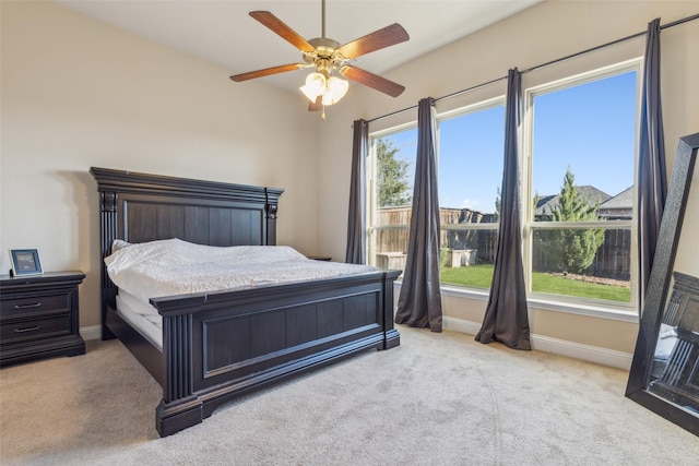 bedroom with multiple windows, ceiling fan, and light carpet