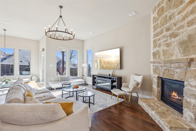 living room with an inviting chandelier, a fireplace, and hardwood / wood-style flooring