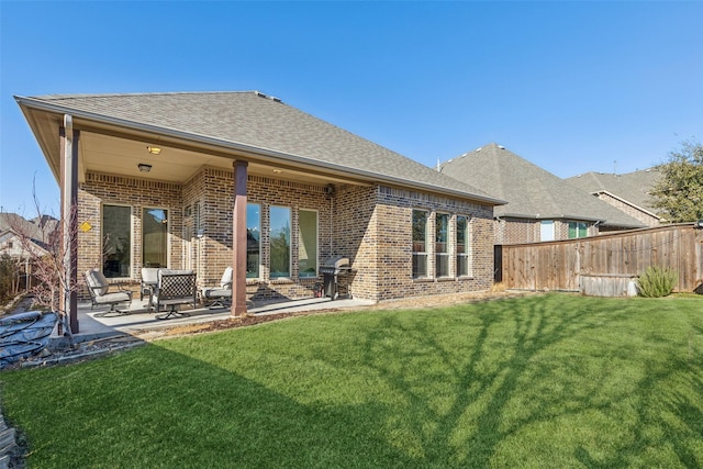 back of house with a patio and a lawn