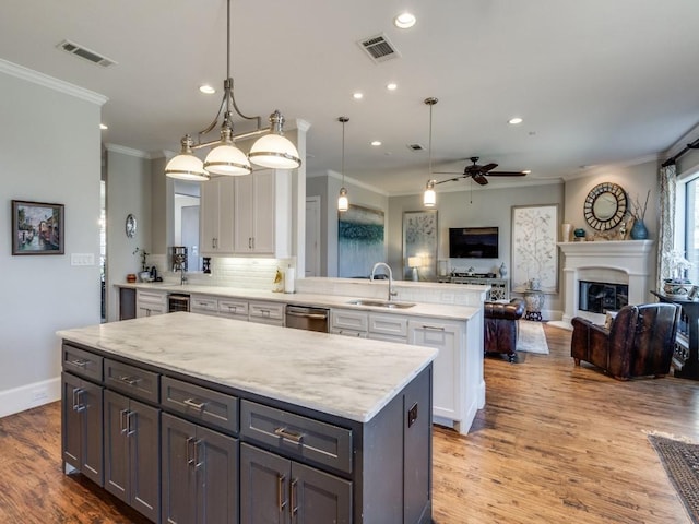 kitchen featuring pendant lighting, sink, a center island, wood-type flooring, and white cabinets