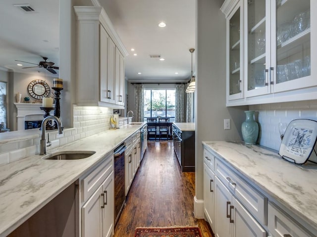 kitchen featuring pendant lighting, sink, white cabinetry, dark hardwood / wood-style flooring, and decorative backsplash