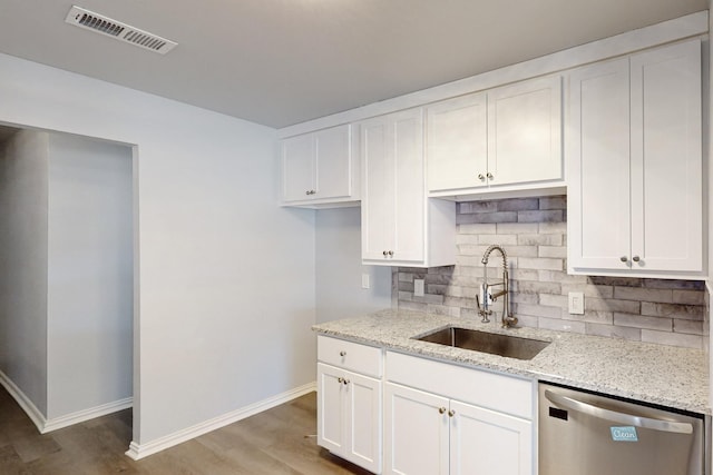 kitchen featuring stainless steel dishwasher, light stone countertops, sink, and white cabinets