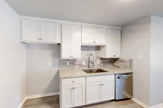 kitchen featuring sink, light stone counters, tasteful backsplash, white cabinets, and stainless steel dishwasher