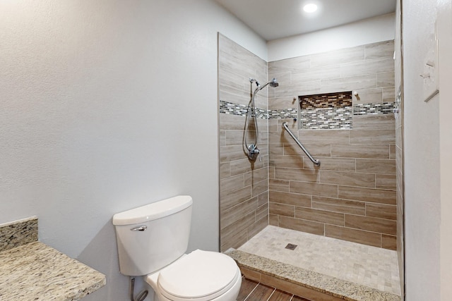 bathroom with tiled shower and toilet