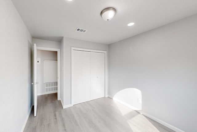 unfurnished bedroom with a closet and light wood-type flooring