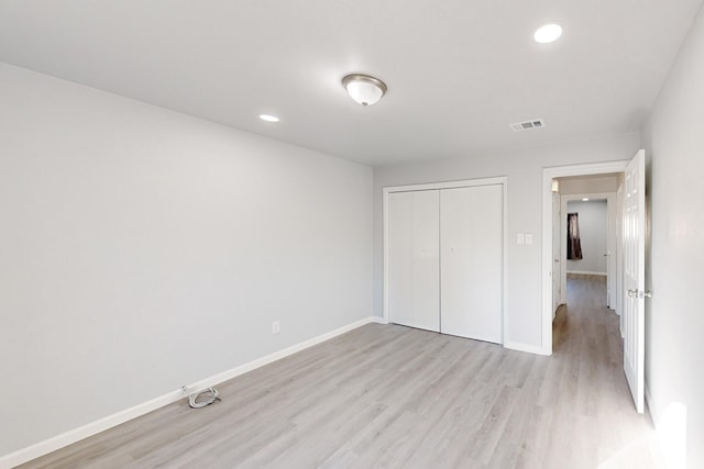 unfurnished bedroom with light wood-type flooring and a closet