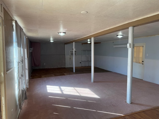 basement featuring a wainscoted wall and a wall mounted AC