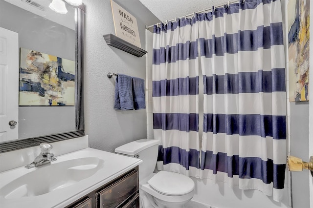 full bathroom featuring vanity, toilet, a textured ceiling, and shower / bath combo with shower curtain