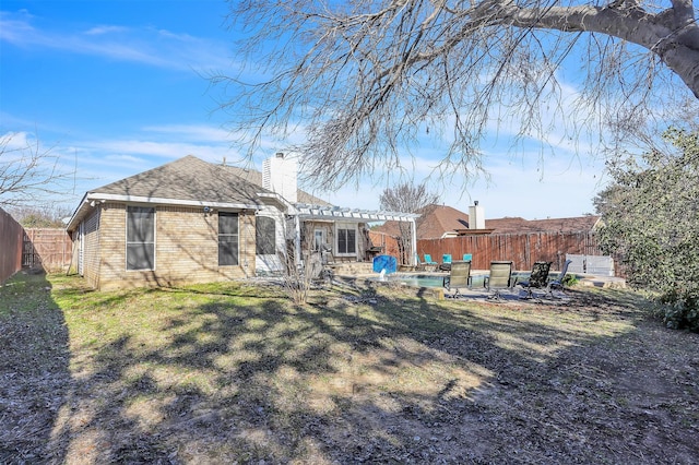 rear view of house featuring a lawn and a pergola