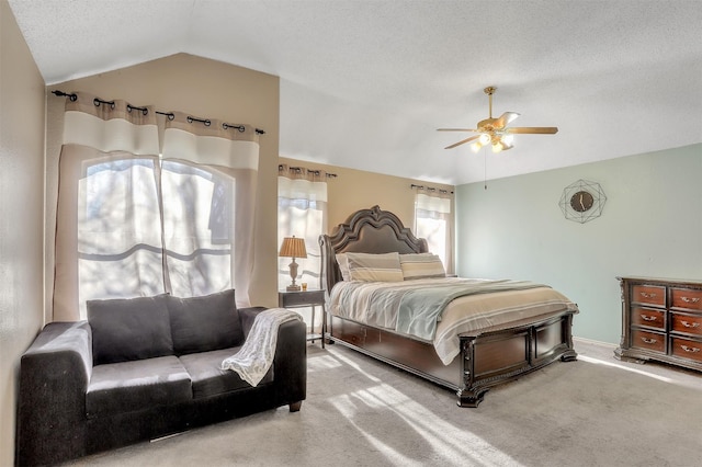 bedroom with ceiling fan, carpet flooring, vaulted ceiling, and a textured ceiling