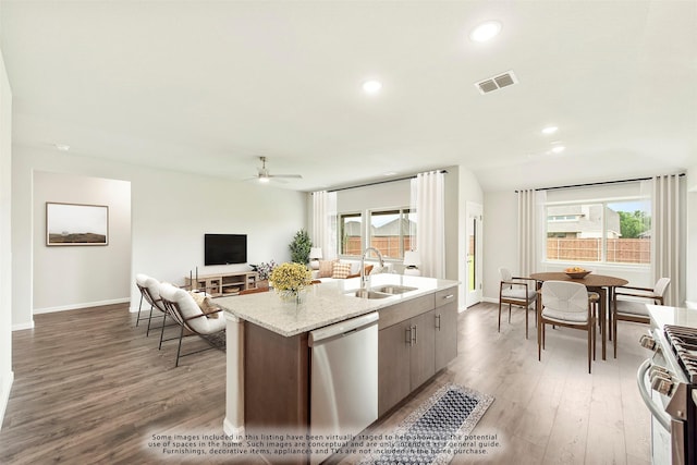 kitchen featuring an island with sink, sink, stainless steel appliances, a healthy amount of sunlight, and light hardwood / wood-style flooring