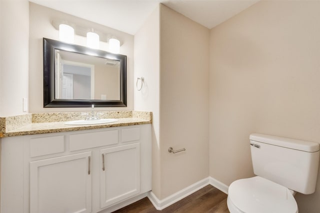 bathroom featuring vanity, hardwood / wood-style floors, and toilet