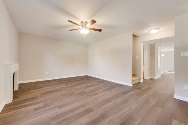 unfurnished living room with hardwood / wood-style floors, a fireplace, and ceiling fan