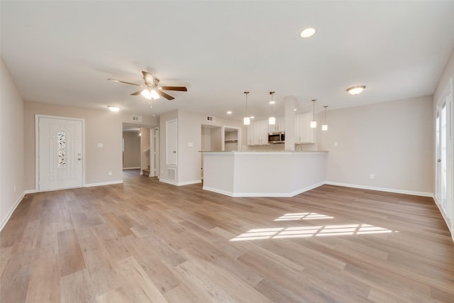 unfurnished living room with ceiling fan and light hardwood / wood-style floors