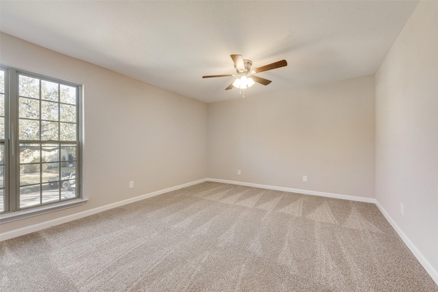 carpeted spare room with ceiling fan