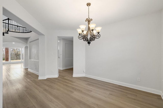 spare room with hardwood / wood-style flooring and a chandelier