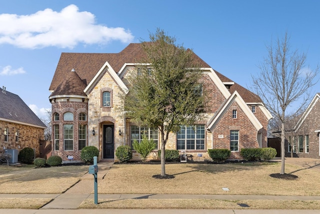 view of front of home with cooling unit and a front lawn