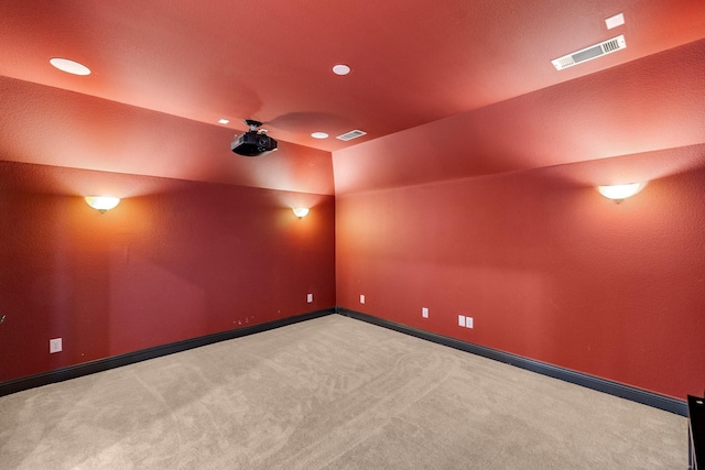 cinema with light carpet and vaulted ceiling