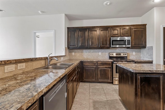 kitchen with sink, light tile patterned floors, appliances with stainless steel finishes, backsplash, and dark brown cabinetry