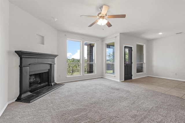 unfurnished living room with ceiling fan and carpet