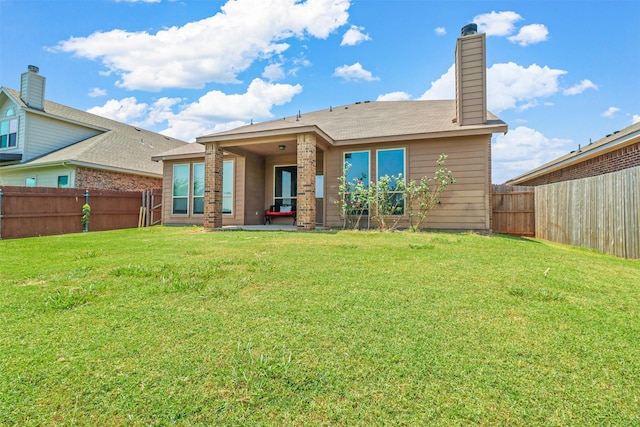 rear view of property featuring a lawn