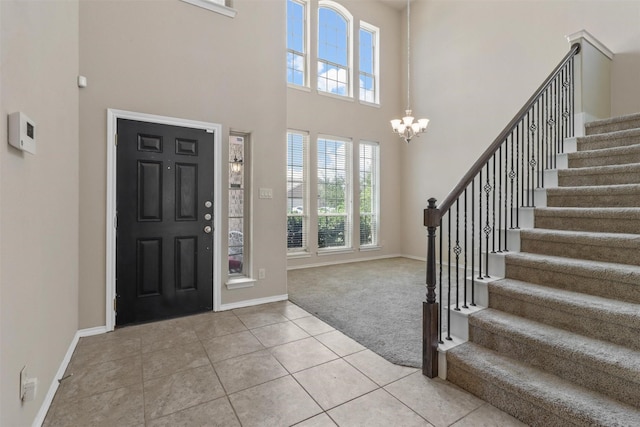 tiled foyer entrance with a towering ceiling and an inviting chandelier