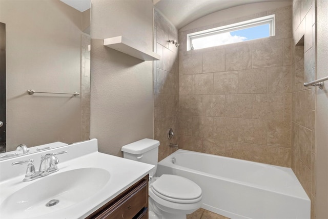 full bathroom featuring tiled shower / bath, vanity, and toilet