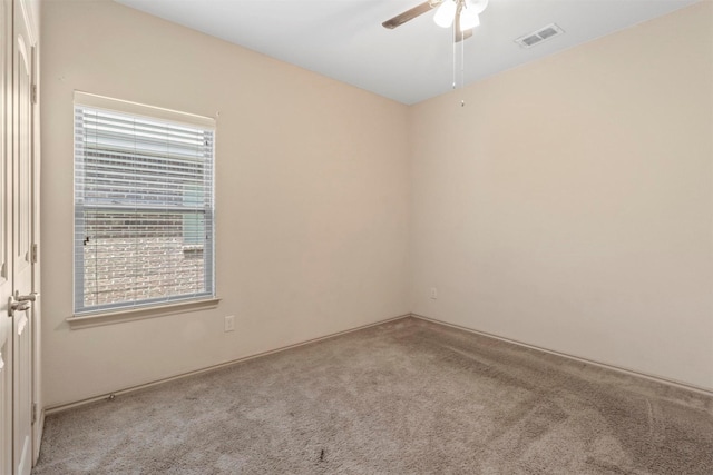 carpeted empty room with ceiling fan and a wealth of natural light