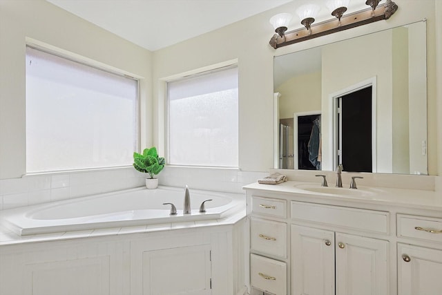 bathroom featuring vanity and tiled bath