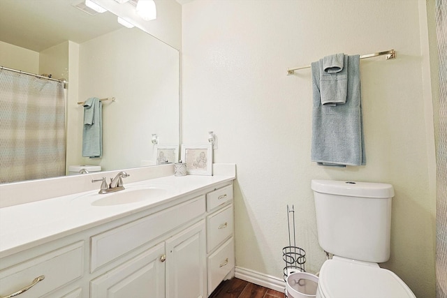 bathroom with wood-type flooring, vanity, and toilet