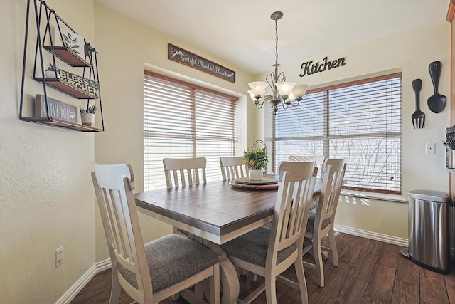 dining space featuring dark hardwood / wood-style floors, a wealth of natural light, and an inviting chandelier