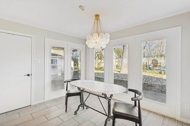 dining area featuring a notable chandelier, french doors, crown molding, and baseboards