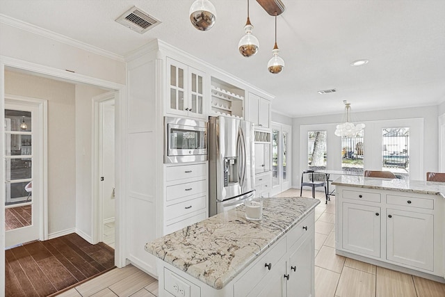 kitchen with wood finish floors, visible vents, pendant lighting, appliances with stainless steel finishes, and white cabinets