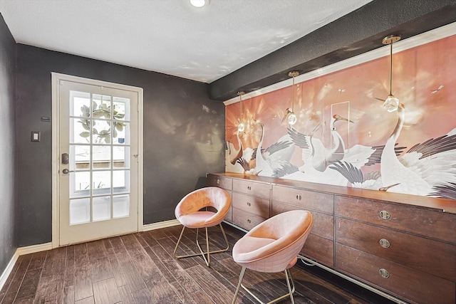 living area with wood finished floors, baseboards, and a textured ceiling