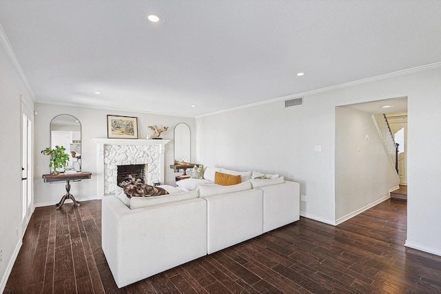 living room featuring visible vents, a stone fireplace, stairs, and wood finished floors