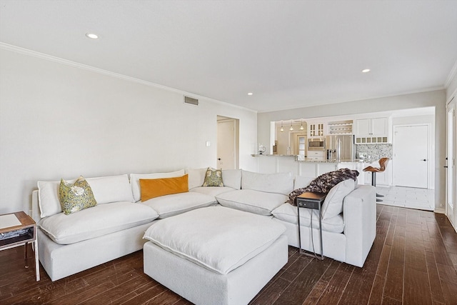 living room with dark wood-type flooring, recessed lighting, crown molding, and visible vents