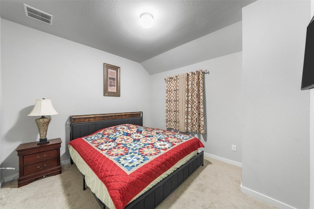 bedroom featuring vaulted ceiling, light carpet, and a textured ceiling