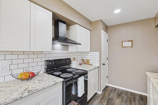 kitchen featuring tasteful backsplash, white cabinetry, wall chimney range hood, and electric range