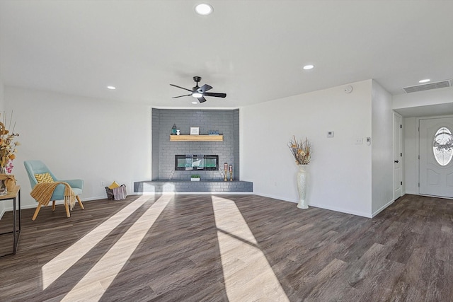 unfurnished living room featuring dark hardwood / wood-style flooring, a fireplace, and ceiling fan