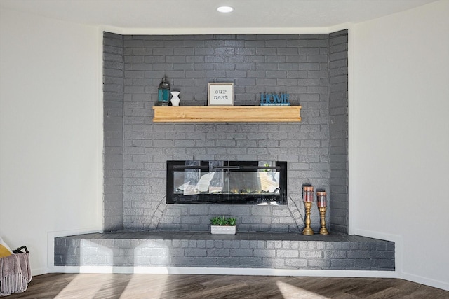 details featuring a brick fireplace and hardwood / wood-style flooring