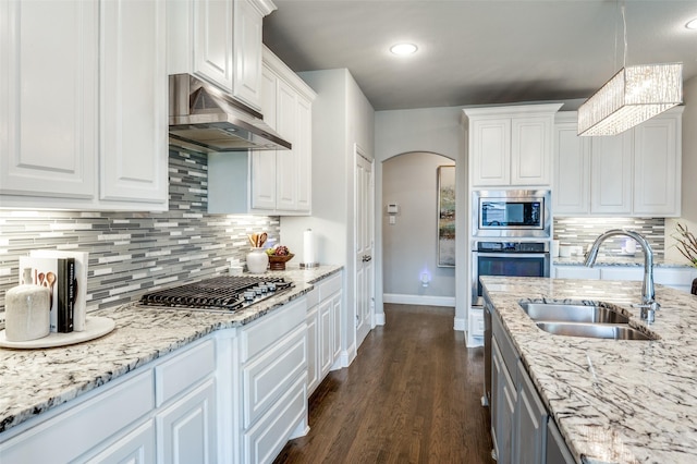 kitchen with pendant lighting, sink, white cabinets, and appliances with stainless steel finishes