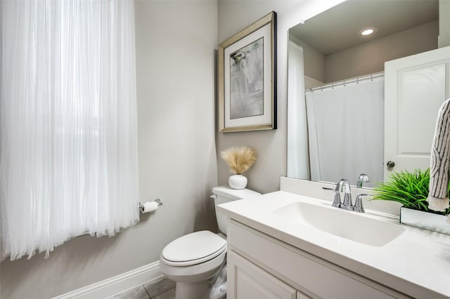 bathroom featuring vanity, tile patterned flooring, and toilet