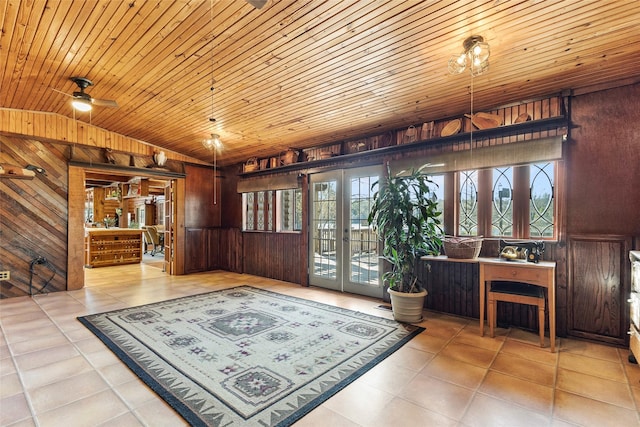 living area featuring a wealth of natural light, wooden ceiling, and wood walls