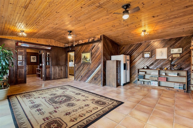 interior space featuring wood walls, vaulted ceiling, and light tile patterned floors