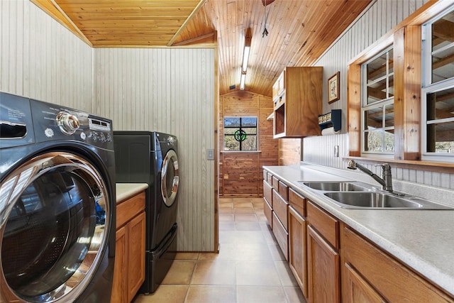 laundry room featuring sink, wood ceiling, light tile patterned floors, wooden walls, and washing machine and dryer