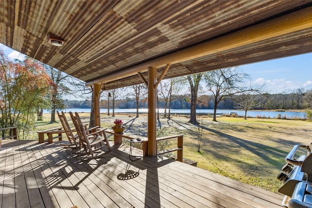 wooden terrace with a yard and a water view