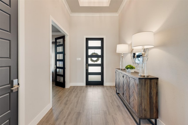 foyer featuring ornamental molding and light wood-type flooring