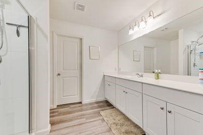 bathroom with vanity, an enclosed shower, and hardwood / wood-style floors